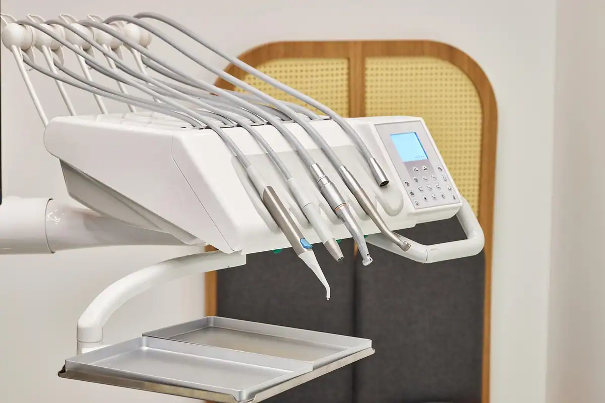 Unit dentar alb cu instrumente rotative, pregătit pentru o intervenție chirurgicală orală