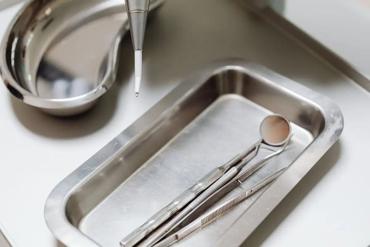 Oglindă și sondă dentară așezate pe o tavă metalică sterilă