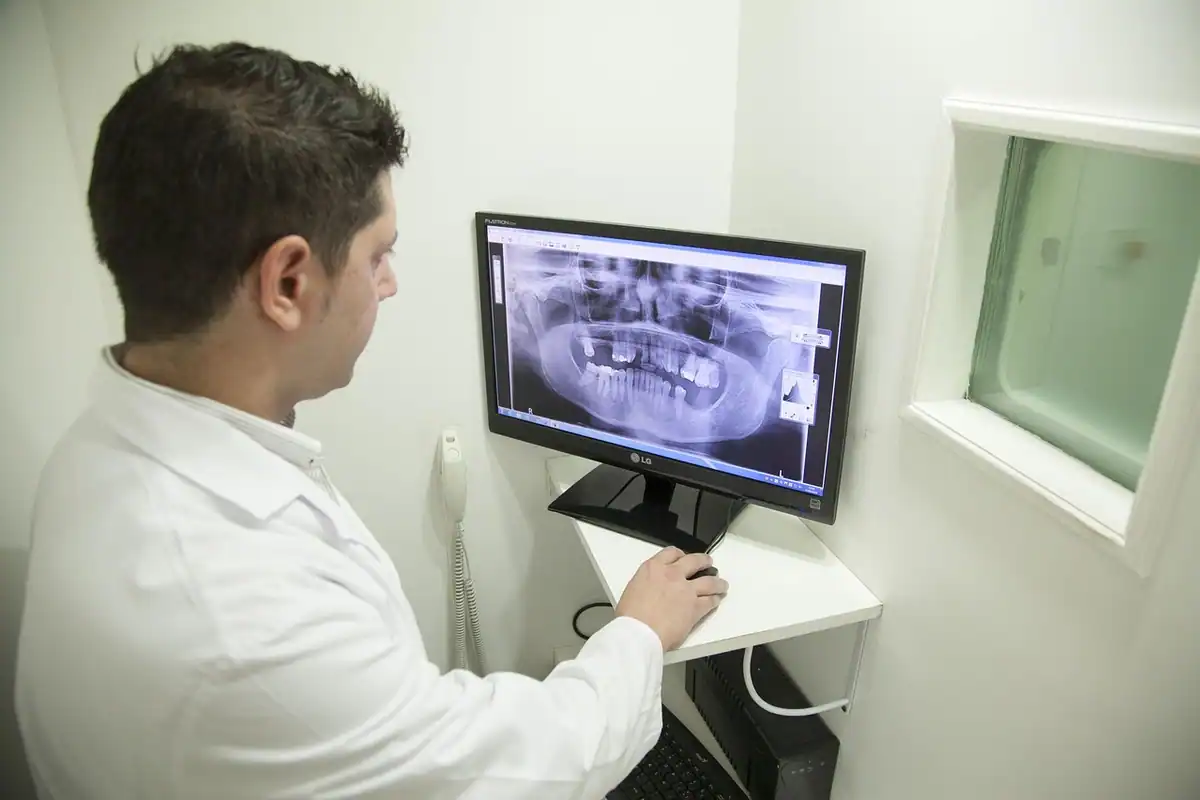 Medic urmărește pe monitor o radiografie panoramică a maxilarelor unui pacient