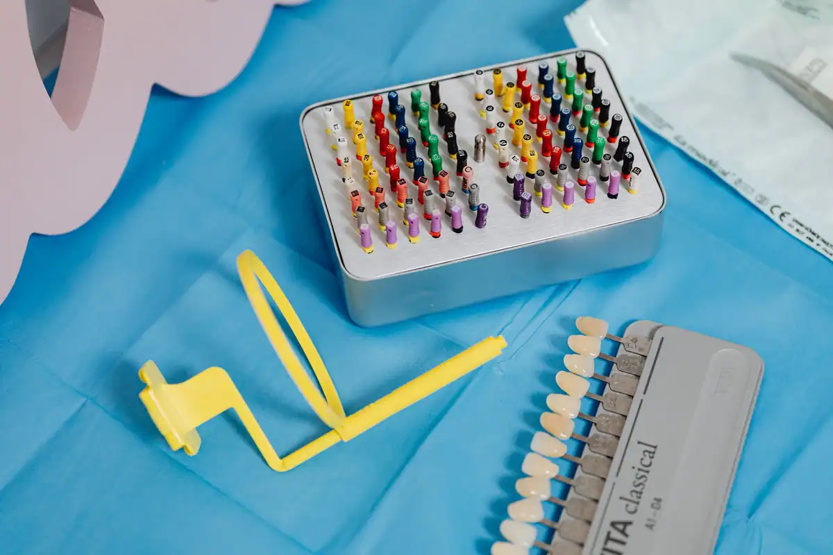 Set de freze endodontice și instrumente stomatologice așezate pe un material albastru